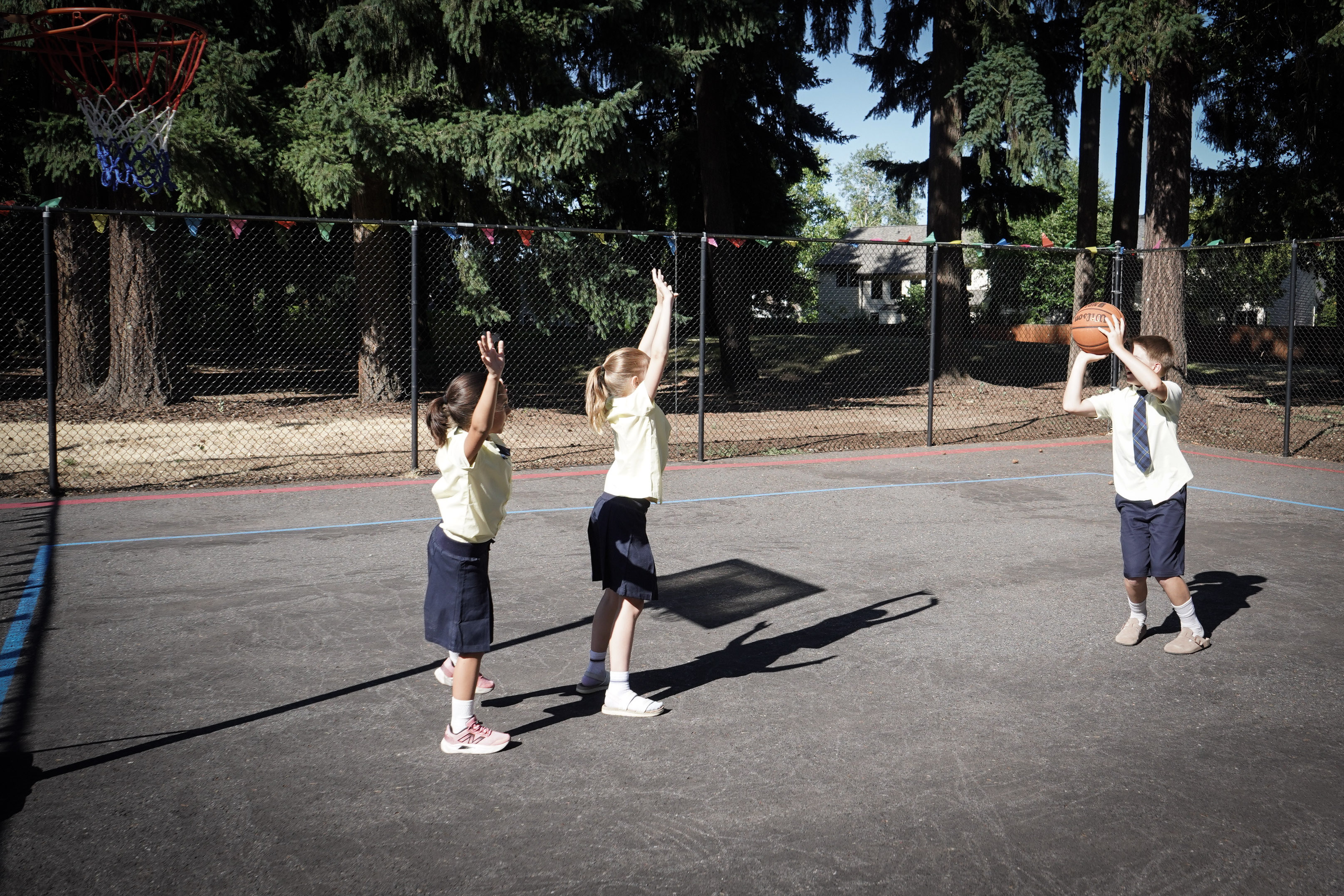 Students playing basketball on the outdoor court