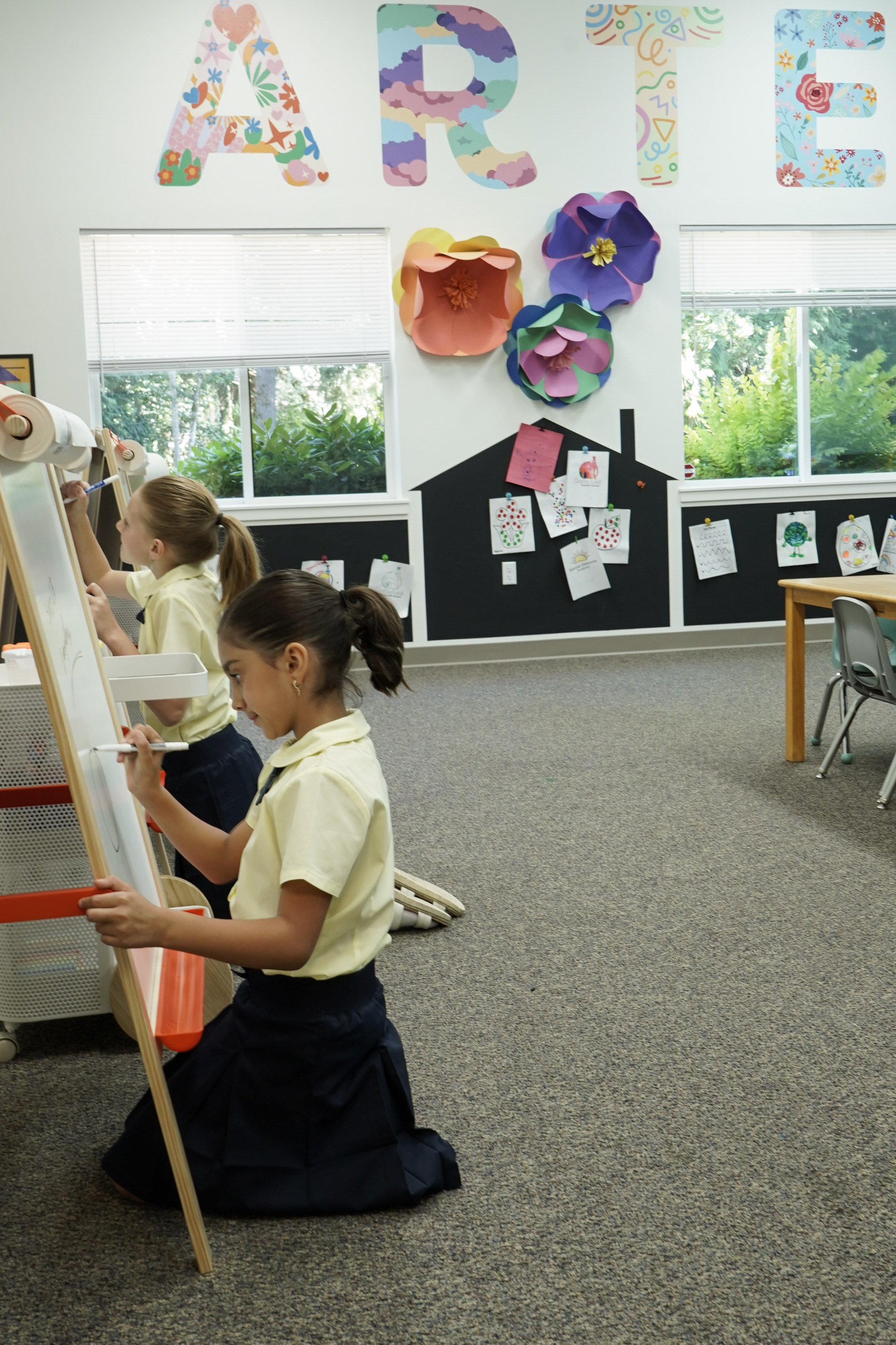Students painting at easels in the art room