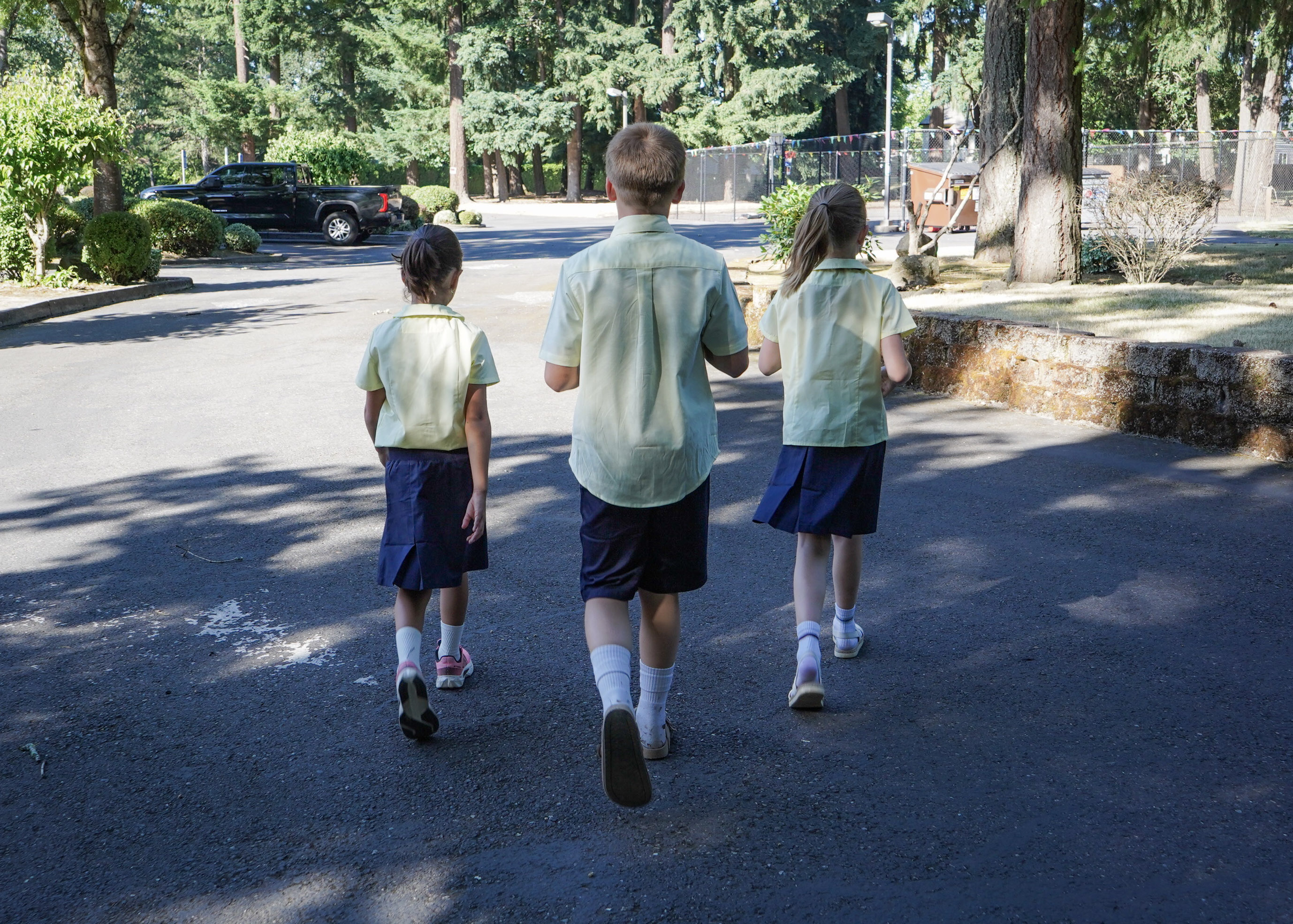 Staff walking a group of students together across the campus grounds